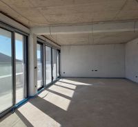 An unfurnished room with large windows in a 3-room apartment, floor with wood decor.