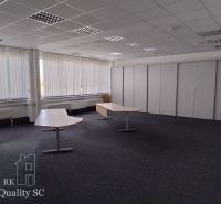 Offices with carpeted floors, white vertical blinds, and contrasting desks.