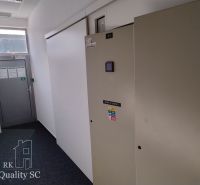 Offices with white walls and dark wood-patterned floors.