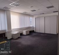 Spacious offices with white furniture and dark carpet, large windows with blinds.