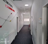 Office corridors with abstract wall decor and carpeted flooring.
