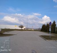 Exterior in Senec with offices, parking lot, and blue sky.