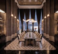 A luxurious dining room with a long table and a view of the city in an apartment development.