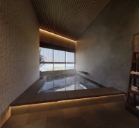 Bathroom with a whirlpool, wooden decor flooring, shelf with towels and cosmetics.