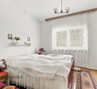 A bedroom in a family house with white walls, red cabinets, and decorations.