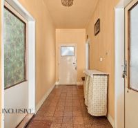 A narrow hallway in a family house with a smooth floor and soft orange walls.