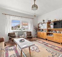 Living room in a family house with a sideboard, armchairs, and a wooden decor floor.