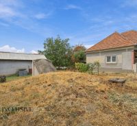 A family house in Bátorove Kosihy with a sloped roof and dry grass in the yard.
