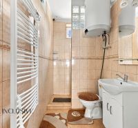 A bathroom in a family house with tiles and white furniture.
