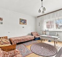 A room in a family house with beds, a television, and a floor with a wooden decor.