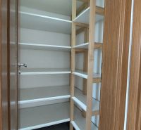 Storage space with shelves in a 2-room apartment, floor with wood decor.