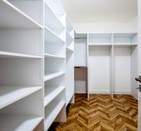 A wardrobe with white shelves and a wooden decor floor in a holiday apartment.