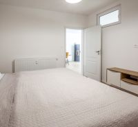 A bedroom in a holiday apartment with a comfortable bed and furniture with a wood decor.