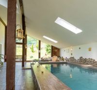 A pool with loungers and stone details in a holiday apartment.