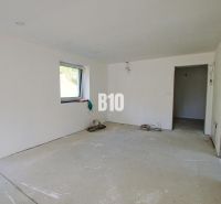 A view of an unfinished room in a family house with a concrete floor.