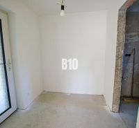 Room in a family house with a concrete floor and glass doors.