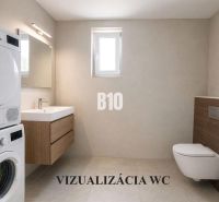 Bathroom with a washing machine, dryer, wall-hung toilet, and sink in a family house.