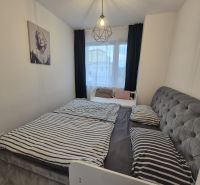 Bedroom in a 3-room apartment with a bed, a painting, and simple lighting.