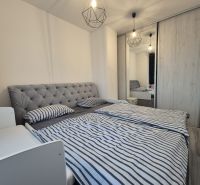 A bedroom with a large upholstered bed and a built-in wardrobe in a 3-room apartment.