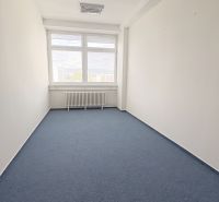 Empty office with blue carpet, large window, and white walls.