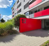 An apartment building on Malokrasňanská Street in Bratislava - Krasňany with distinctive red elements.