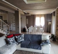 Living room of the villa with white chairs and comfortable seating.