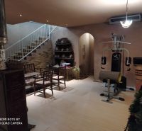 Interior of a villa with a fitness machine, a sofa set, and a wooden decor floor.