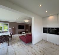 Living room with dining area and kitchen unit in a family house.