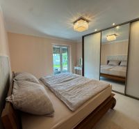 Bedroom in a family house with a large wardrobe, bed, and garden view.