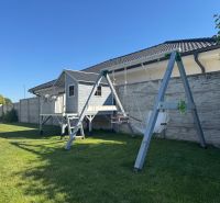 The garden at the family house on Slnečnicová in Miloslavov with a swing and a children's playhouse.