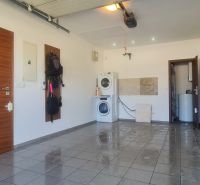 Laundry room in a family house with a washing machine and dryer on tiles.