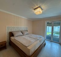 Bedroom in a family house, bed with a decorative headboard and sliding glass doors.