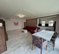 Living room in a family house with a white dining table and a sofa.