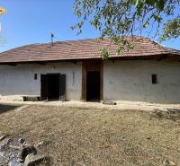 A cottage in Čaka with an old roof, double doors, and a large yard.