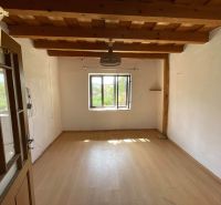 A room in a cottage with a wooden ceiling and a floor with a wooden decor.