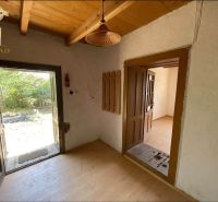 Charming cottage interior with wood-decor flooring and a view of the outdoor yard.