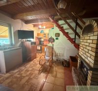 The interior of a cabin with a fireplace, a wooden decor floor, and a wooden ceiling.