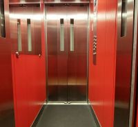 The interior of a red elevator in a three-room apartment with mirrored elements on the walls.