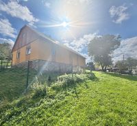 A family house in Košariská in Oščadnica surrounded by a green lawn and trees.