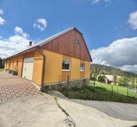 A family house on Košariská Street in Oščadnica, surrounded by greenery and blue skies.