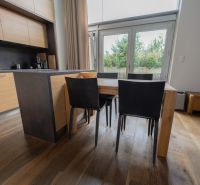 A kitchen in a 4-room apartment with a wooden decor floor and modern furniture.
