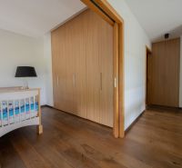 A crib, wardrobe, and floor with a wooden decor in a 4-room apartment.