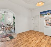 A family house with a wooden decor floor, a dining table, and a refrigerator.