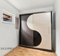 Built-in wardrobe with sliding doors and floor with wood decor in a family house.