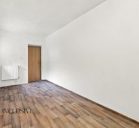 A room in a family house with a wooden decor floor and a simple radiator.