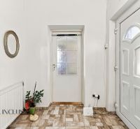 A hallway of a family house with white doors and a decorative mirror on the wall.