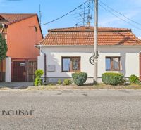 A family house in Komárno with a white facade, red roof, and well-maintained garden.
