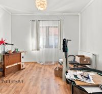 A room in a family house with a wooden decor floor, a table, a window, and decorations.