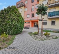 The building on Platan Street in Šamorín with bicycles at the entrance and landscaping.