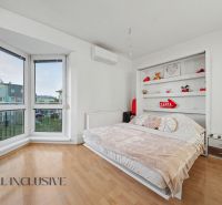 Interior of a 1-room apartment with a bed, shelf, and floor with wood decor.